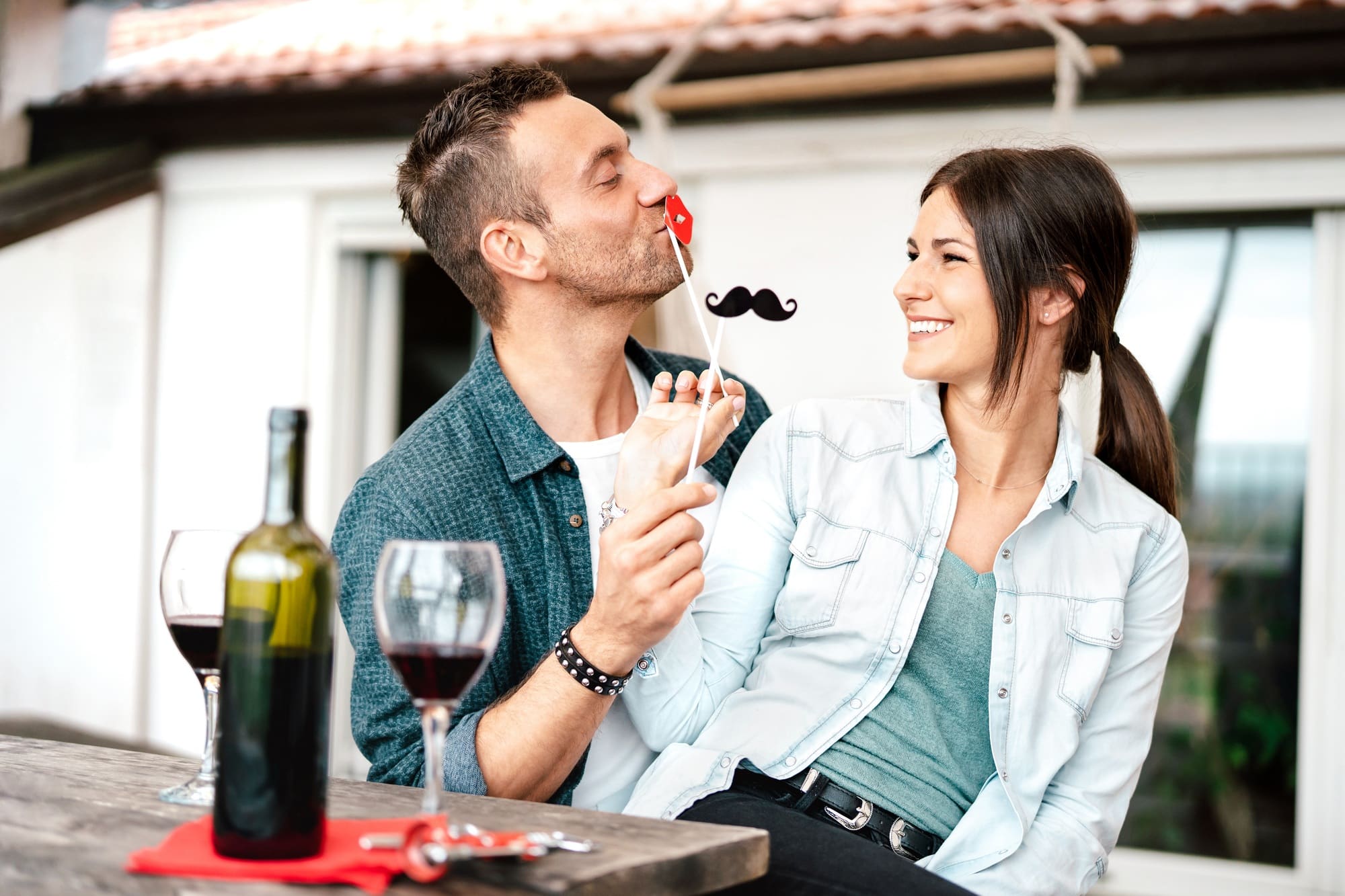 Funny couple in love drinking red wine at patio terrace