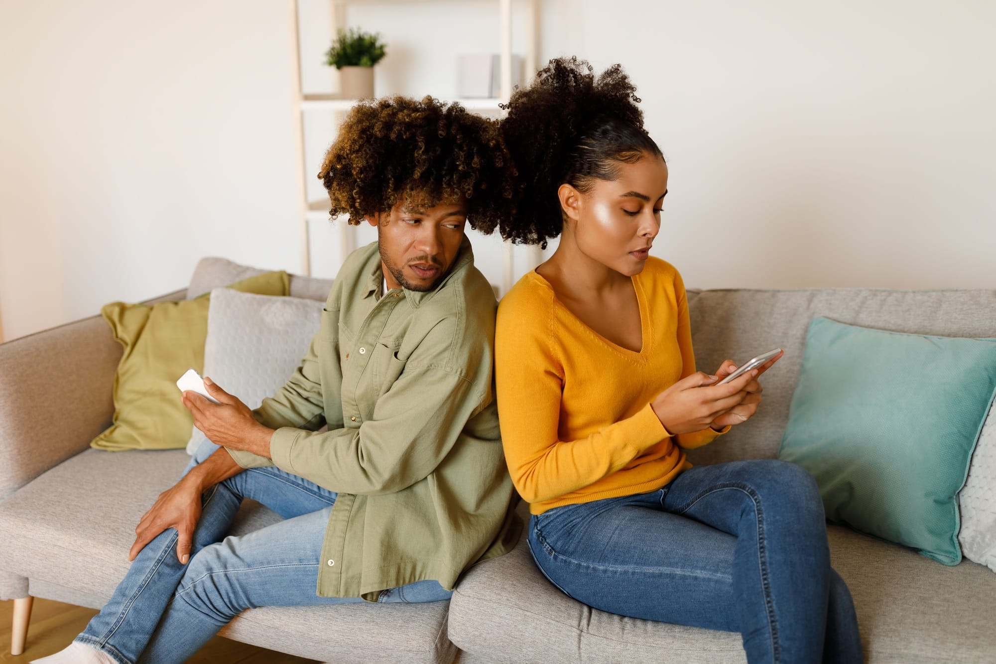 Jealous African Boyfriend Peeking At Girlfriend's Phone Suspecting Infidelity Indoors