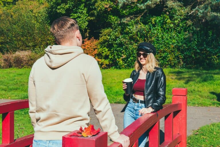 Young people communicating outdoor following social distancing rules. Date in the park