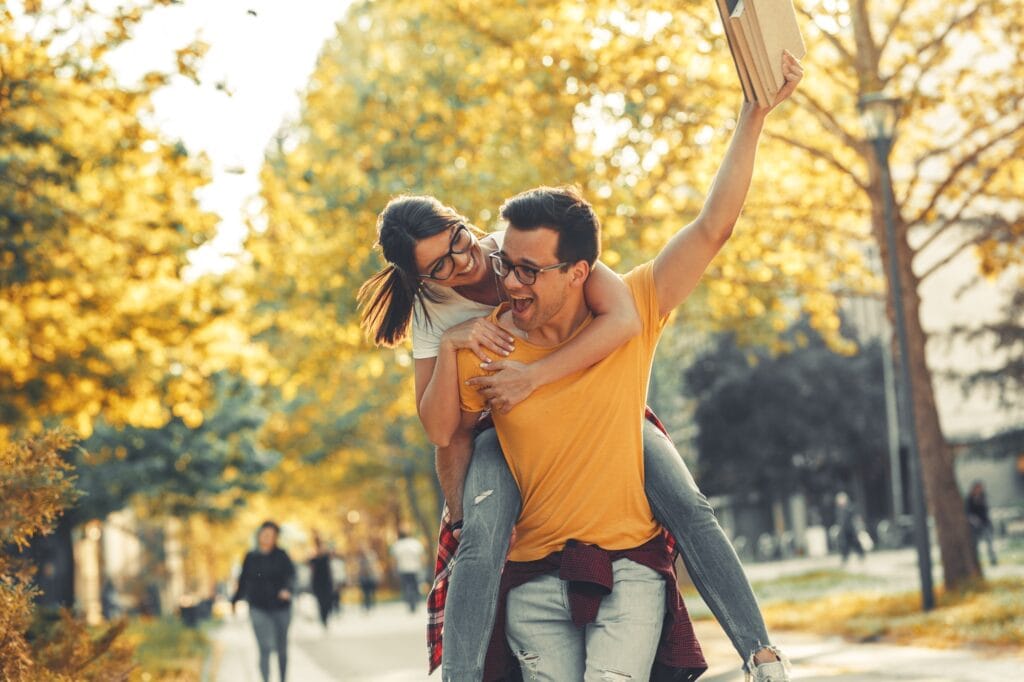 Young student couple having fun at the campus yard.
