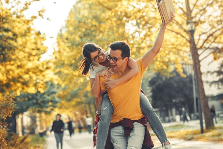 Young student couple having fun at the campus yard.
