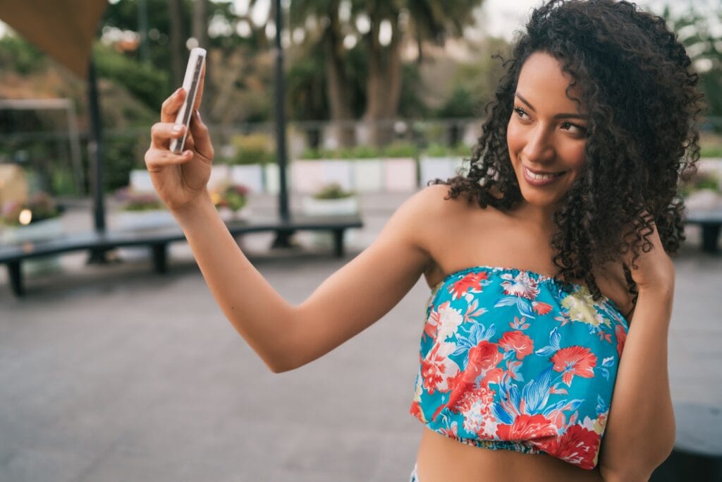 Afro American latin woman taking a selfie with phone.