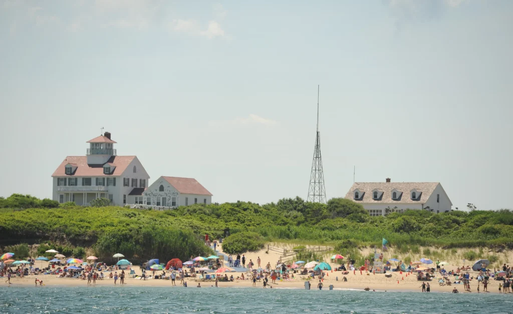 Coast Guard Beach in Eastham, Cape Cod, showing historic Coast Guard buildings and a sandy shoreline where people gather, later a popular spot for a winter beach walk date.